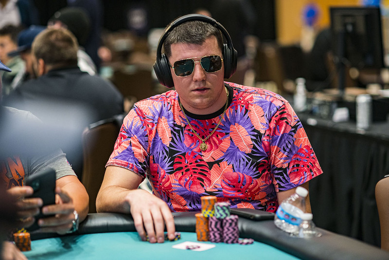 Jonathan Little making a strategic all-in move with A♥-10♥, facing a critical moment at the poker final table against Jesse Lonis.